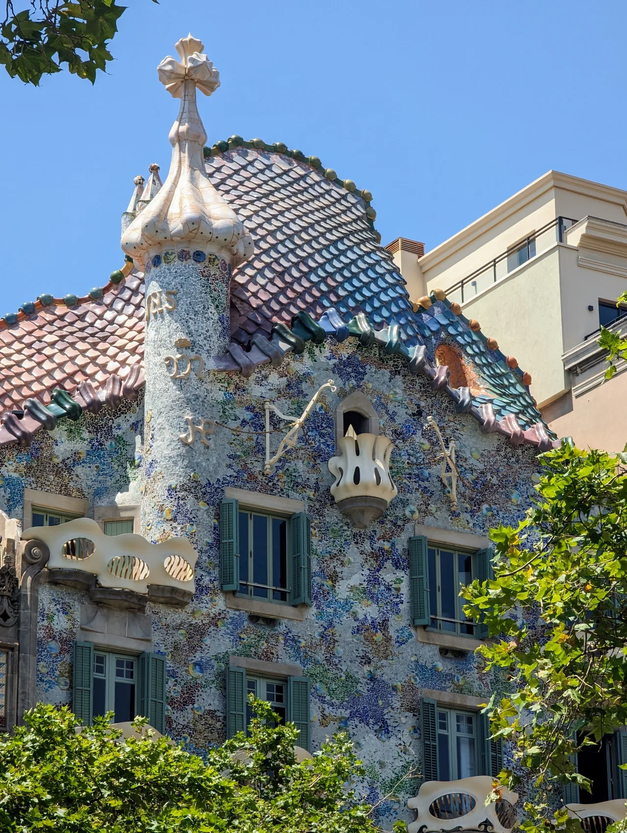 Détail de la façade de la Casa Batlló à Barcelone, avec ses mosaïques colorées, ses balcons sculptés et son toit en écailles imaginé par Antoni Gaudí.